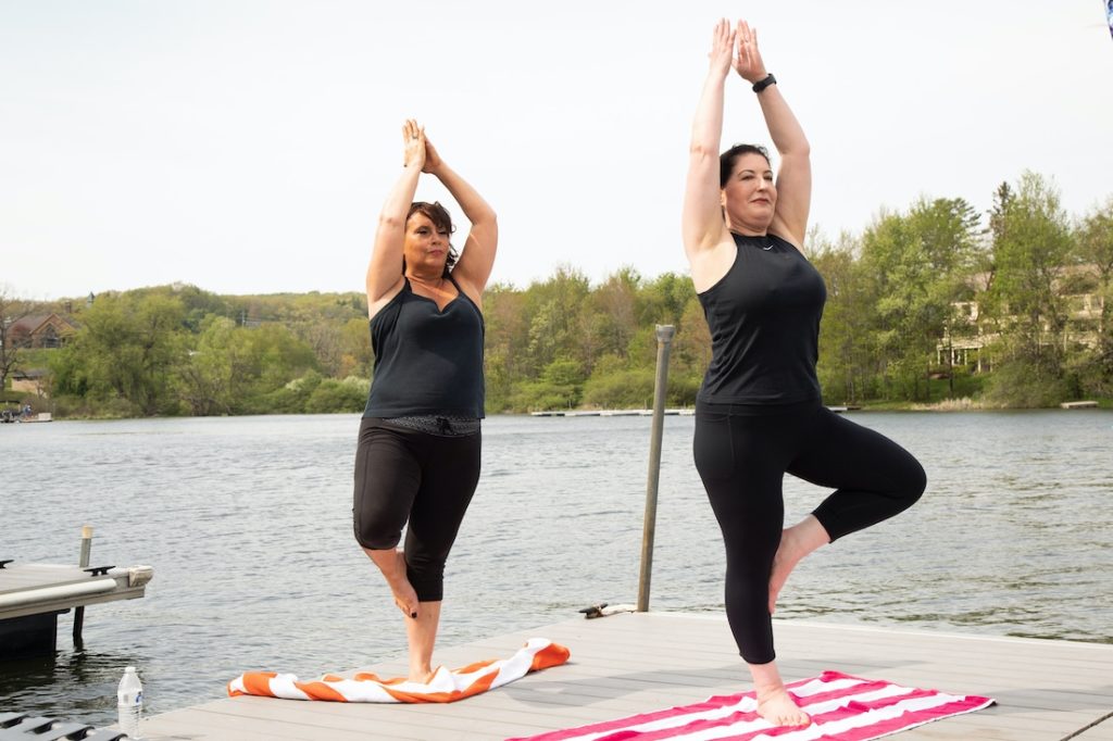 Things to do in Deep Creek, MD, two women doing yoga out on the dock at the Lake Pointe Inn